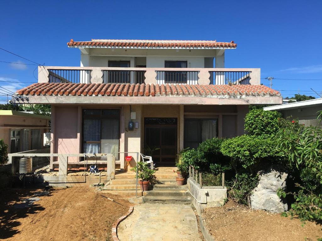 een huis met een balkon er bovenop bij Minnkayado intoparitosura in Miyako Island