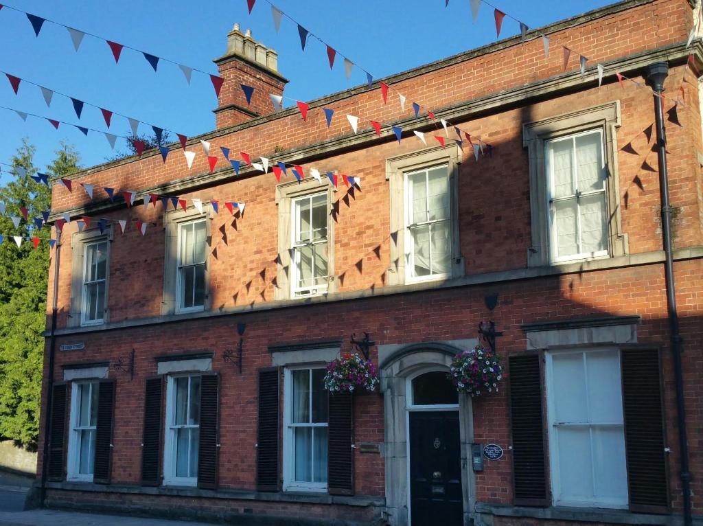 a red brick building with flags on it at Madge House Ashbourne in Ashbourne