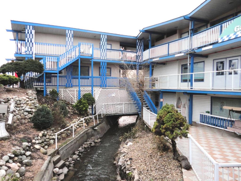 a building with a river in front of it at Blue Stream Motel in Vernon