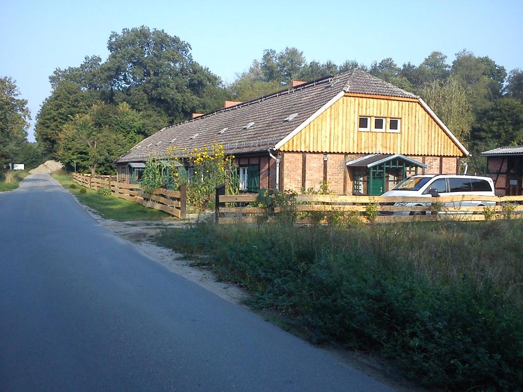 a house with a fence and a car parked in front of it at Ferienwohnungen 3 Birken in Briesen
