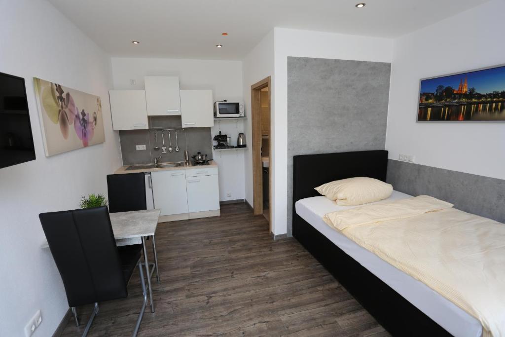 a small room with a bed and a kitchen at Hecht Apartments in Mallersdorf-Pfaffenberg