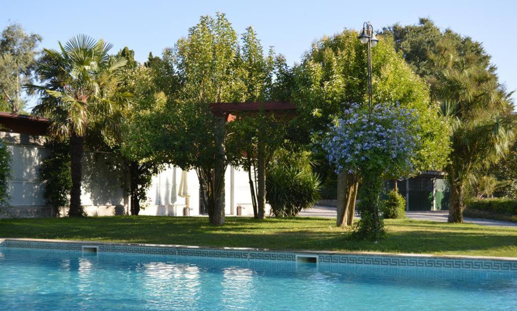 a swimming pool in front of a house with trees at Quinta Do Padrao in Penafiel