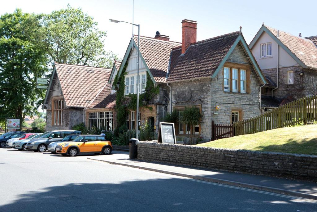 ein gelbes Auto, das vor einem Haus parkt in der Unterkunft Bear Inn, Somerset by Marston's Inns in Street