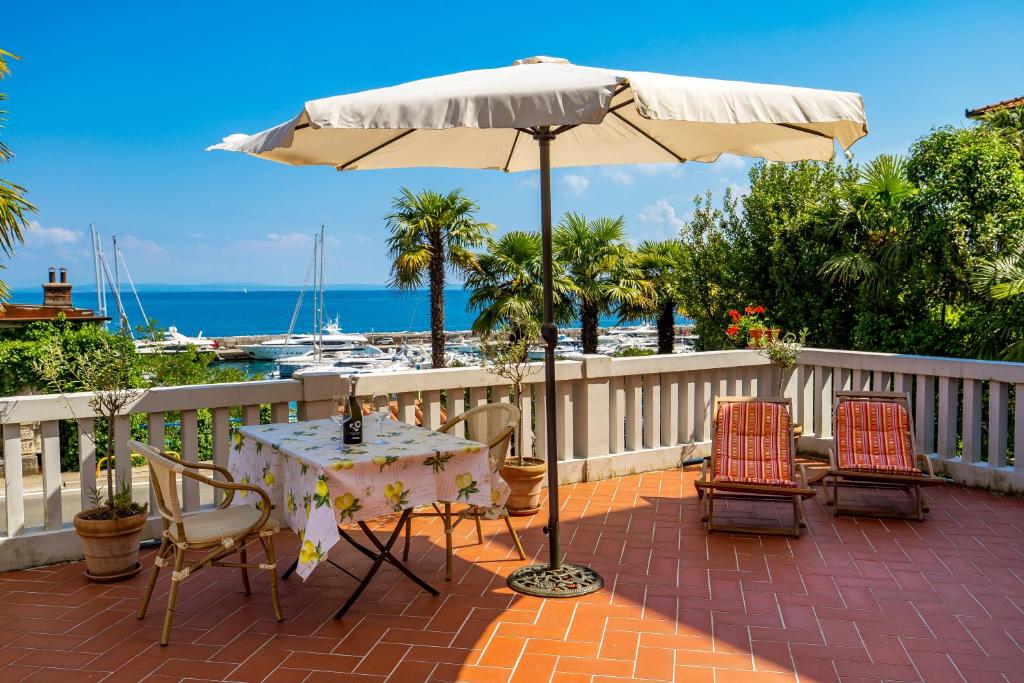 a table and chairs with an umbrella on a patio at Rona Apartments Ani in Ičići