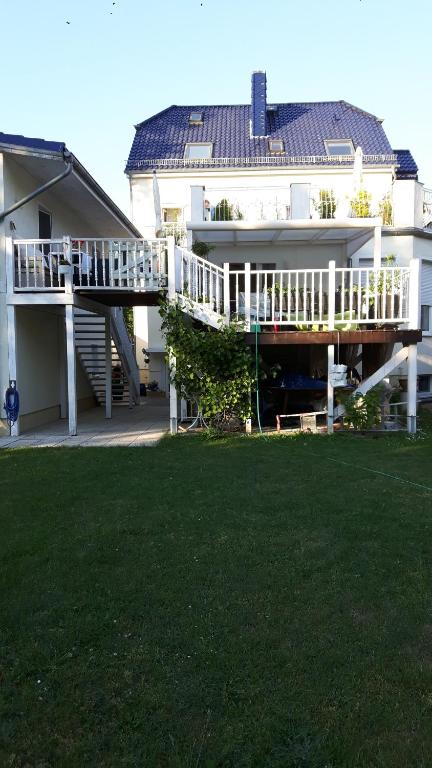 una grande casa bianca con terrazza e cortile di Ferienapartment MOHNBLUME a Eichwalde