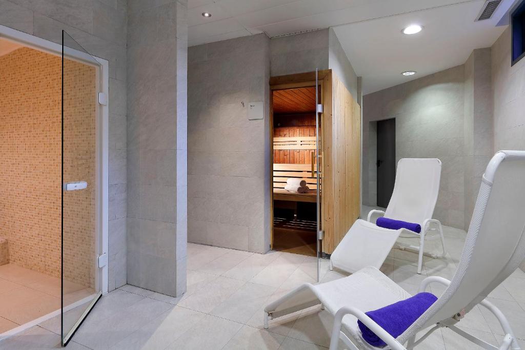 a room with white chairs and a walk in closet at Hotel SB Icaria in Barcelona