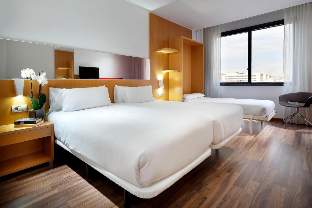 a hotel room with two beds and a desk at Hotel SB Icaria in Barcelona