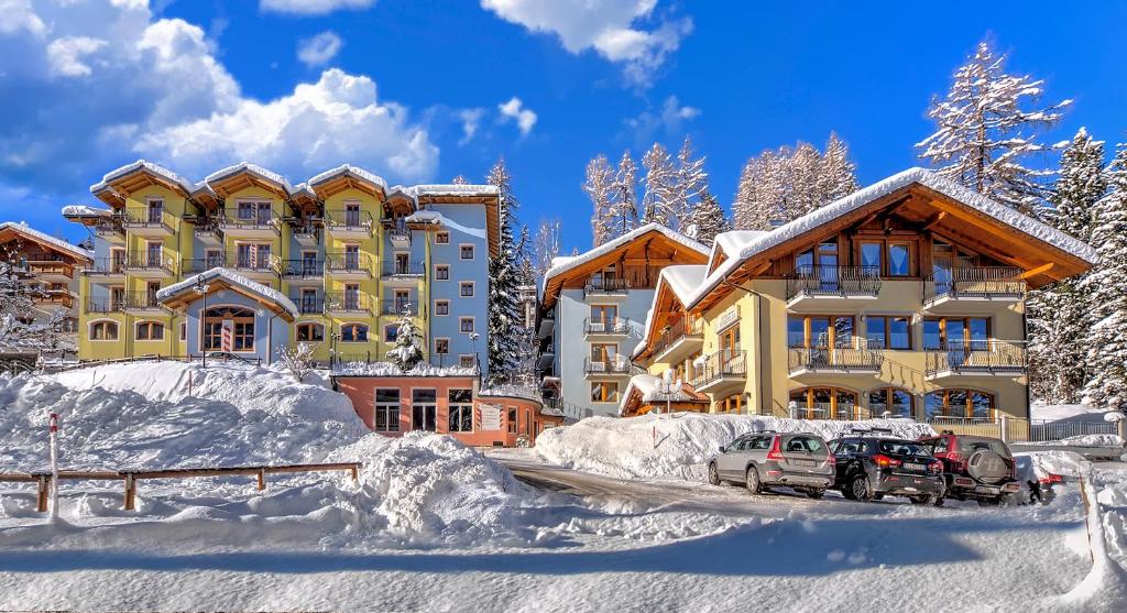 a house in the snow with a car parked in front at Hotel Negritella in Folgarida