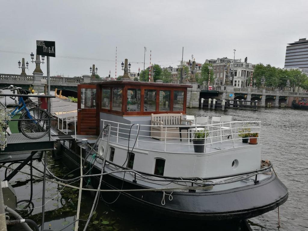 a boat is docked at a dock in the water at houseboat Rose in Amsterdam