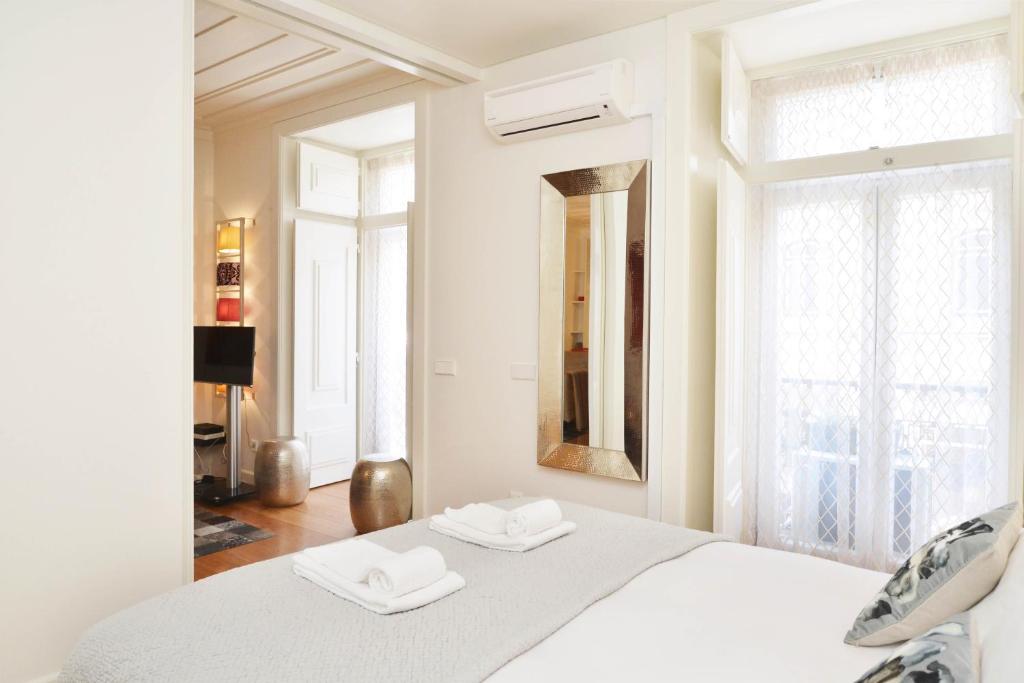 Habitación blanca con cama y ventana en Chiado Luxury Experience - Checkinhome, en Lisboa