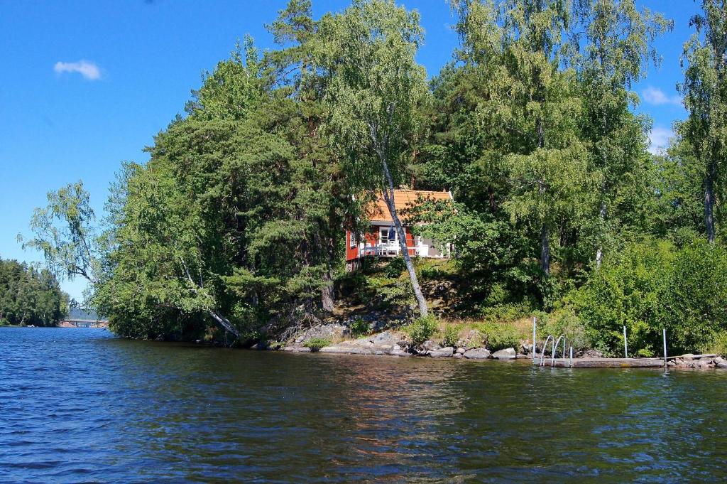 ein Haus am Ufer eines Sees in der Unterkunft Sjöstuga vid Bunn Gränna - Uddastugan in Gränna