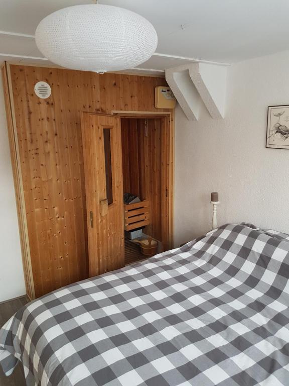 een slaapkamer met een zwart-wit geruit bed bij Unieke stadswoning voor 2 personen met Finse sauna in Apeldoorn
