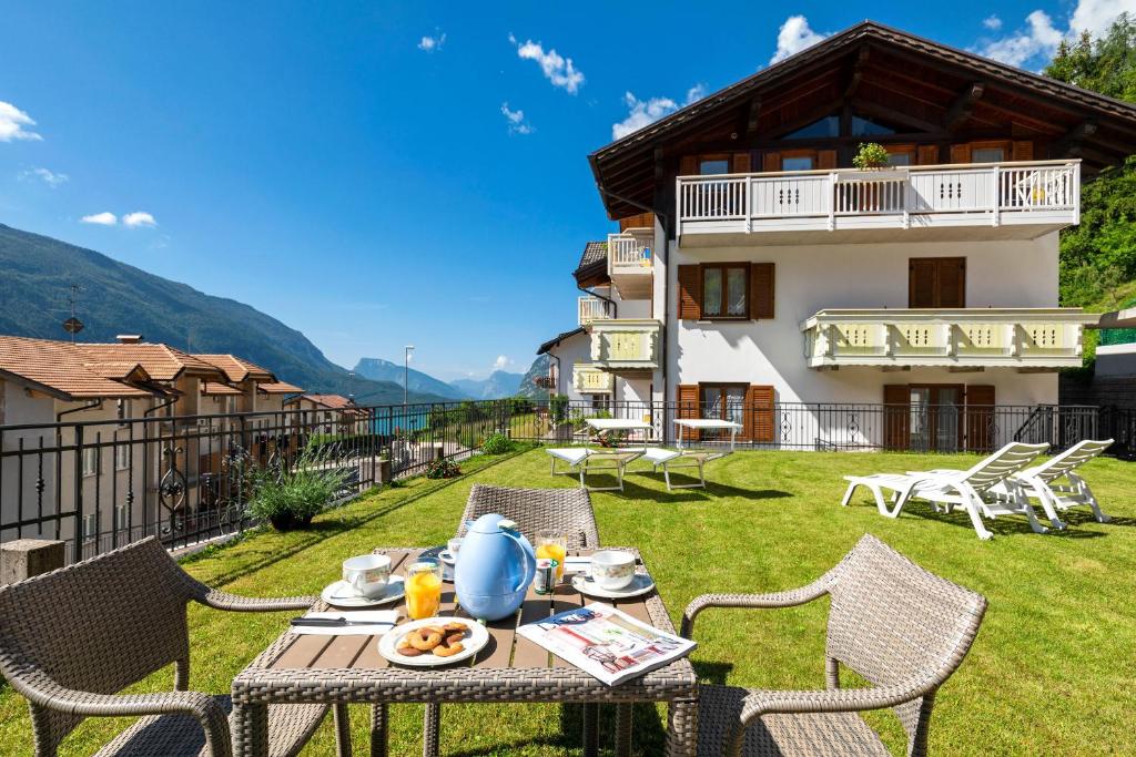 a patio with a table and chairs in front of a house at Appartamenti Residenza Pineta in Molveno