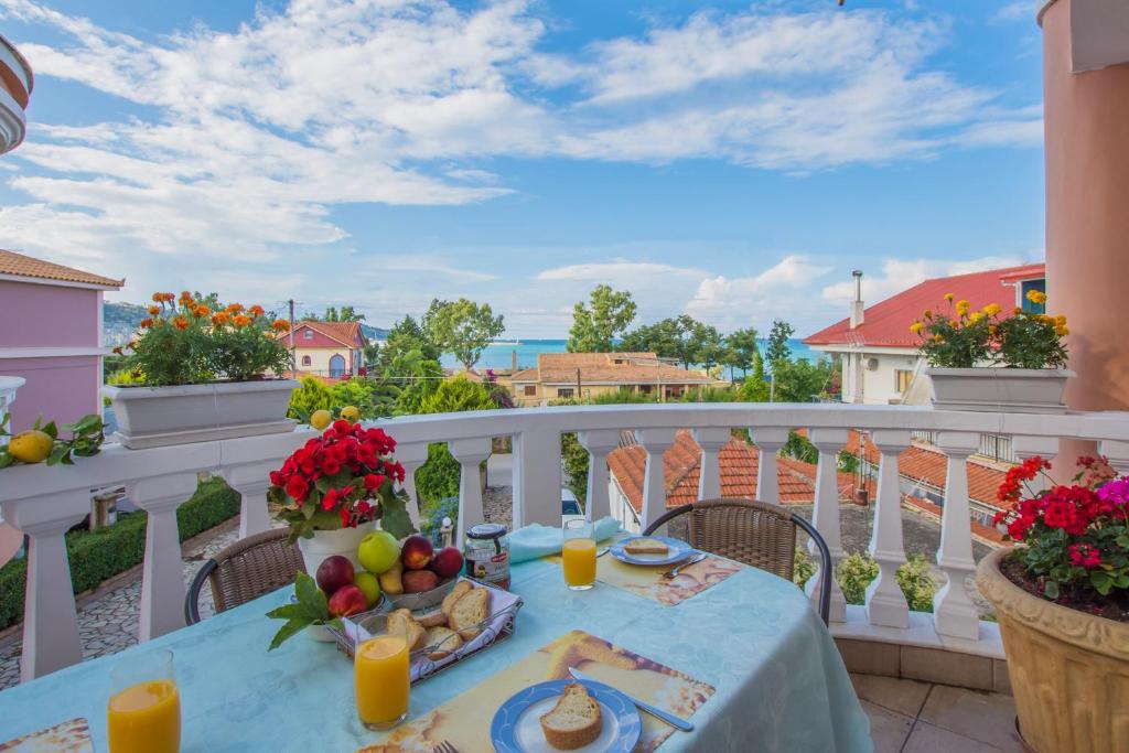 una mesa en un balcón con comida y fruta. en Zante View (4bedroom luxury home) Free Pickup en Zakynthos
