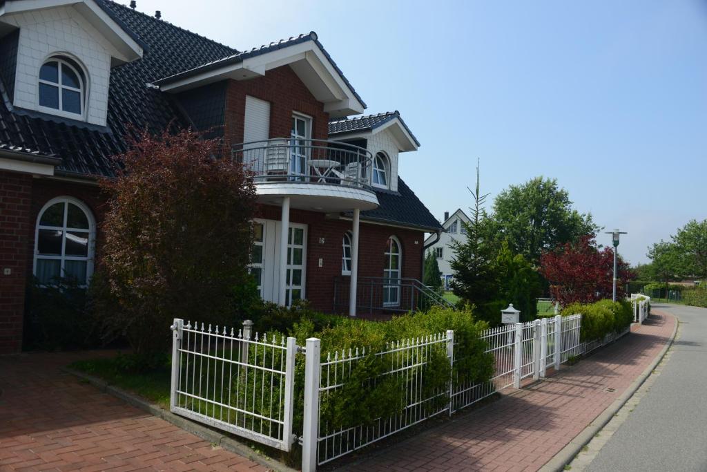 een huis met een wit hek ervoor bij Ferienwohnung Tietgens in Hohenfelde