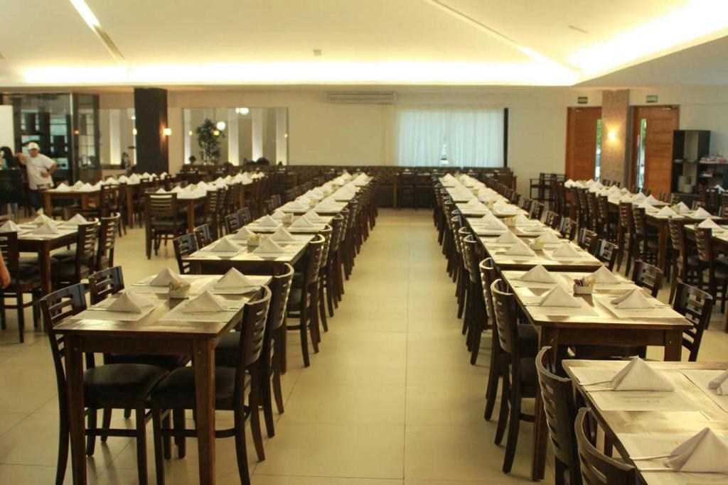 a large room filled with tables and chairs with white napkins at Uchôa Teresina Hotel in Teresina