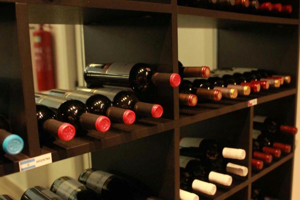 a bunch of wine bottles on a shelf at Uchôa Teresina Hotel in Teresina