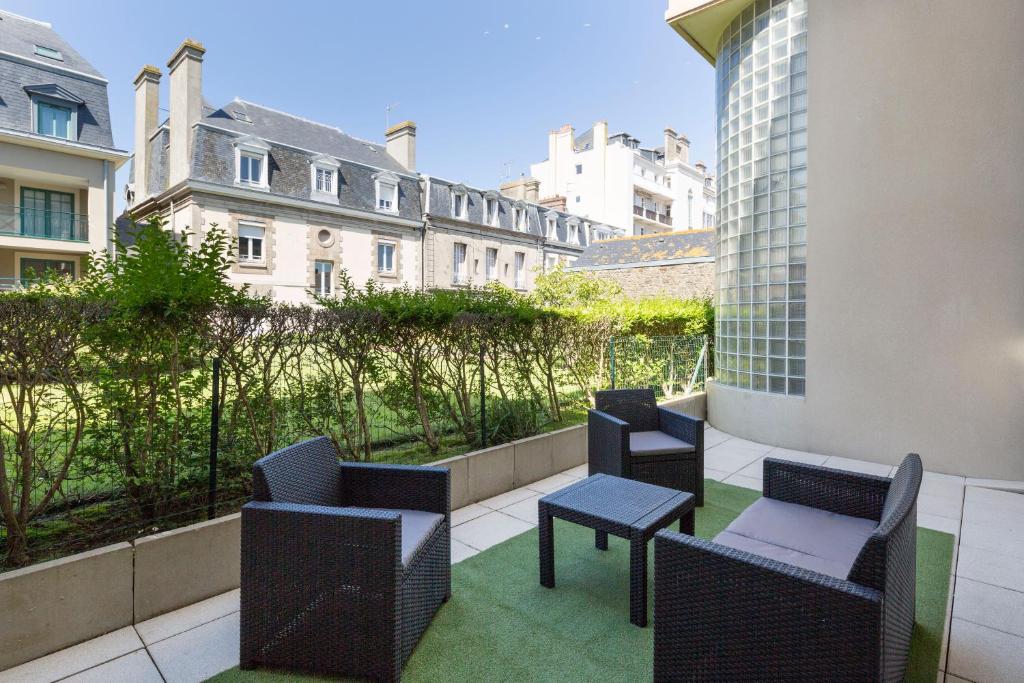 - un balcon avec des chaises et des tables dans un bâtiment dans l'établissement Au Quai Des Pecheurs by Cocoonr, à Saint-Malo