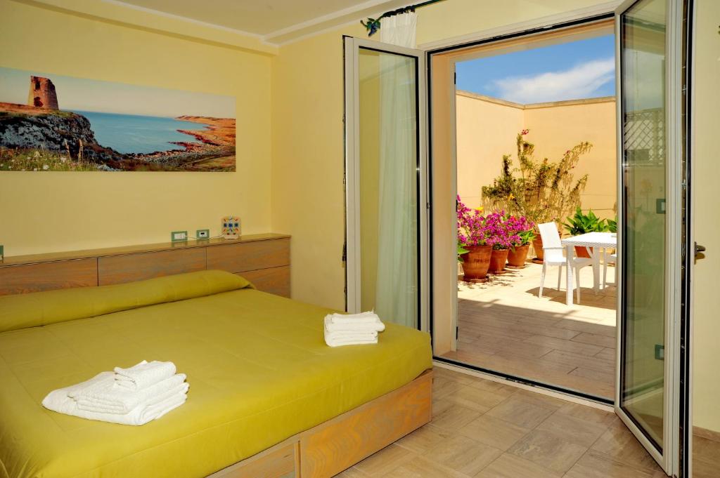Schlafzimmer mit einem Bett und einer Glasschiebetür in der Unterkunft Cala Dei Normanni - Camere sulle Mura in Otranto
