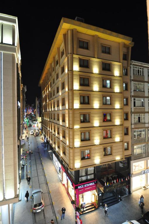 a tall yellow building on a city street at night at Hotel Buyuk Sahinler in Istanbul