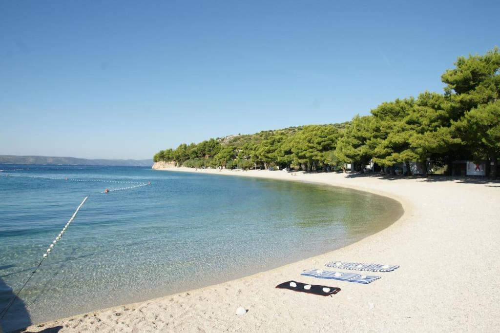 a beach with two flip flops on the beach at Top Location in Živogošće