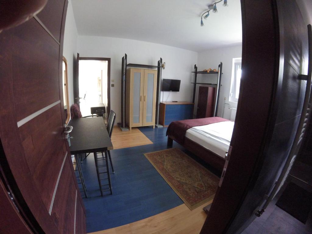 a bedroom with a bed and a desk and a door at Dózsaház in Zalaegerszeg