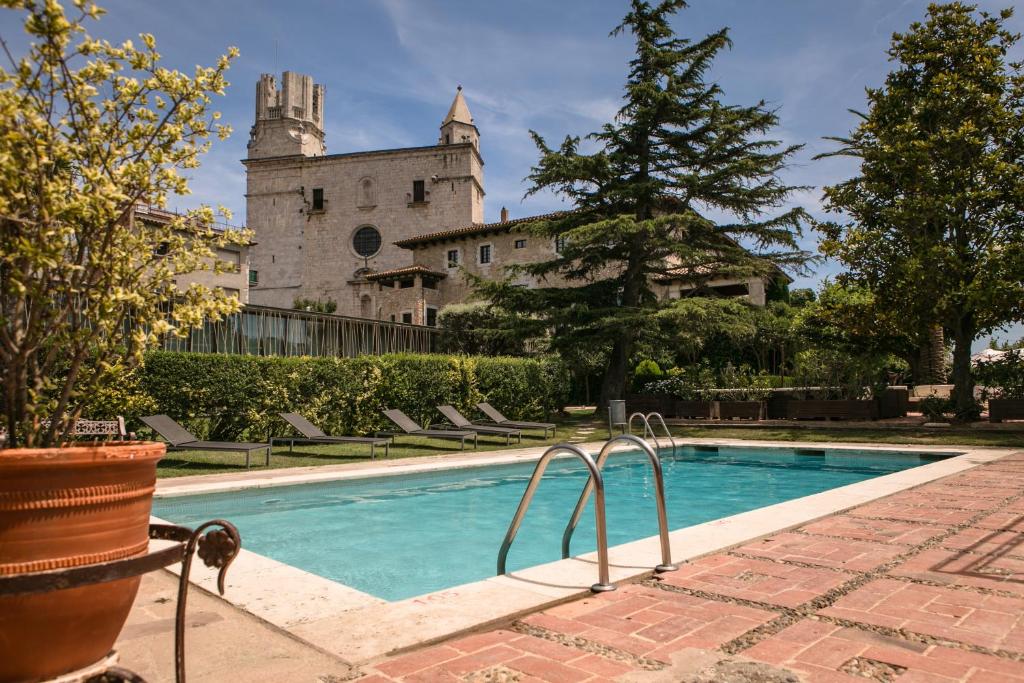 une piscine en face d'un château dans l'établissement RVHotels Hotel Palau Lo Mirador, à Torroella de Montgrí