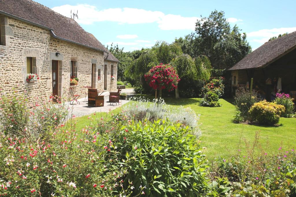 Saint-Denis-sur-Sarthon的住宿－Chambre d'hôte Courtoux，鲜花屋前的花园