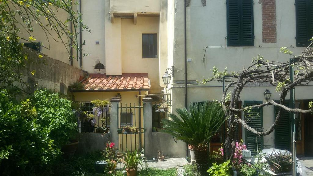 un edificio con cancello e piante in un cortile di Vacantara a Pisa