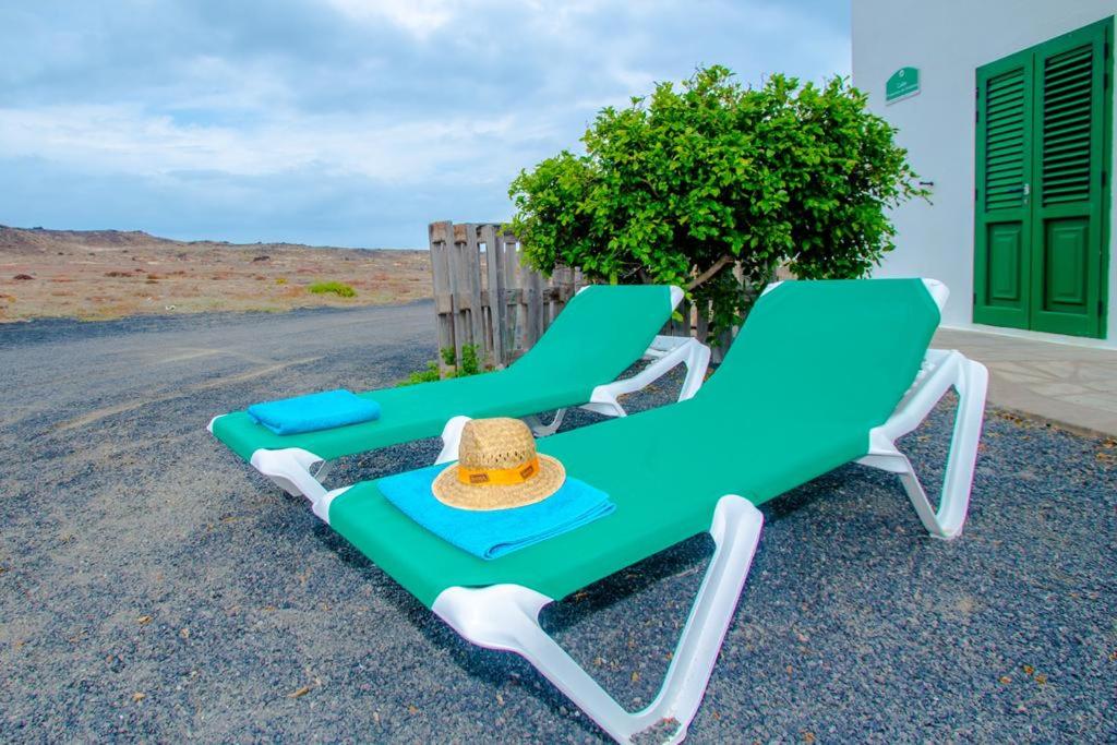 two lounge chairs with a hat sitting on the road at Casa Caleta Beach in Caleta de Caballo