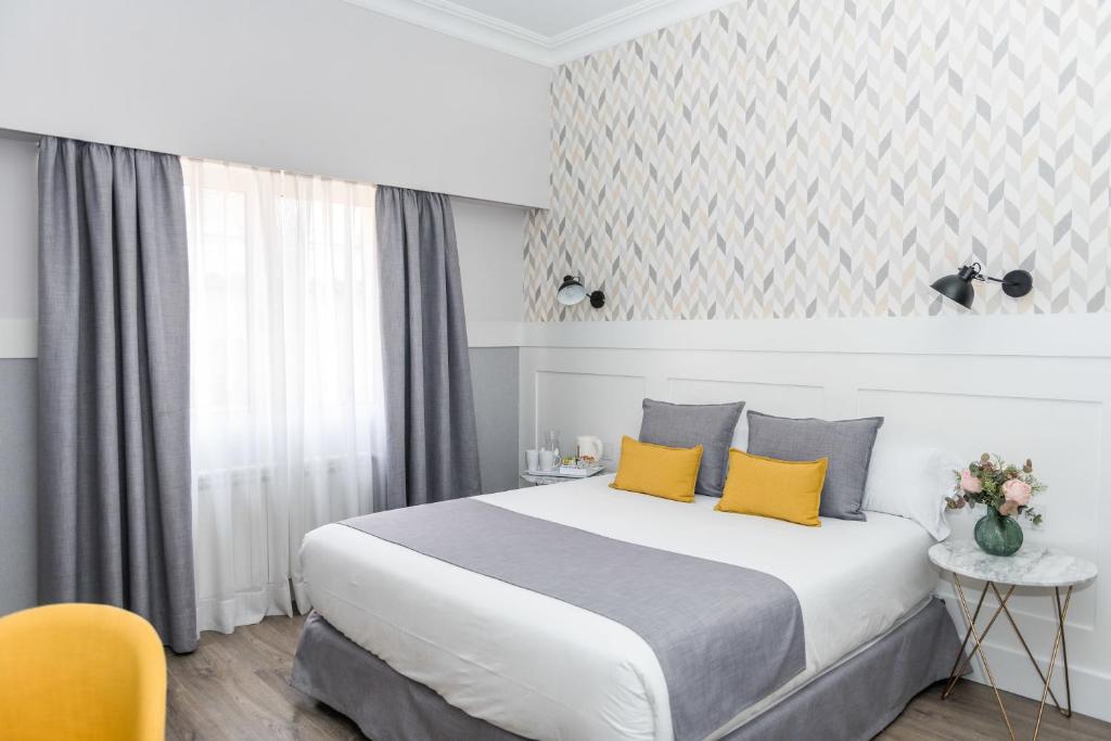 ein Hotelzimmer mit einem großen Bett mit gelben Kissen in der Unterkunft BYPILLOW Velázquez 45 in Madrid