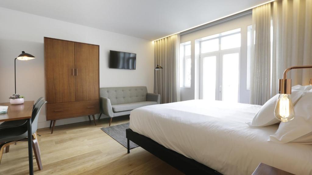 1 dormitorio con cama, escritorio y silla en Braga Heritage Lofts en Braga