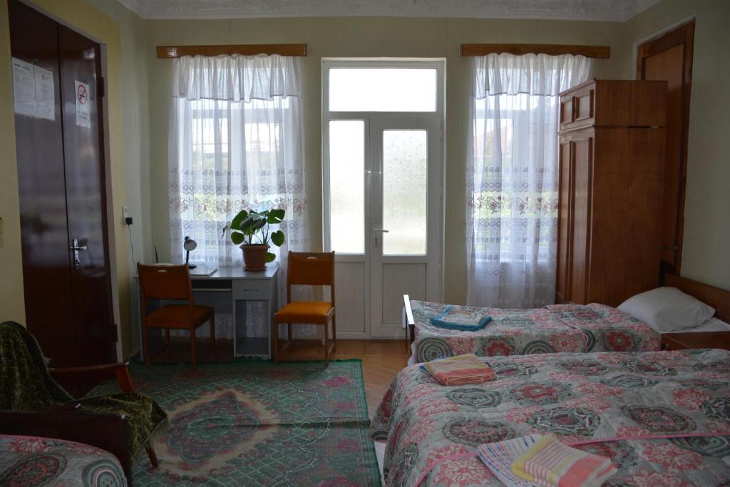 a bedroom with two beds and a table and a desk at Friends House in Kutaisi