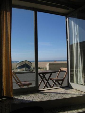 a balcony with two chairs and a view of the beach at One step from the beach, praia da Aguda in Arcozelo