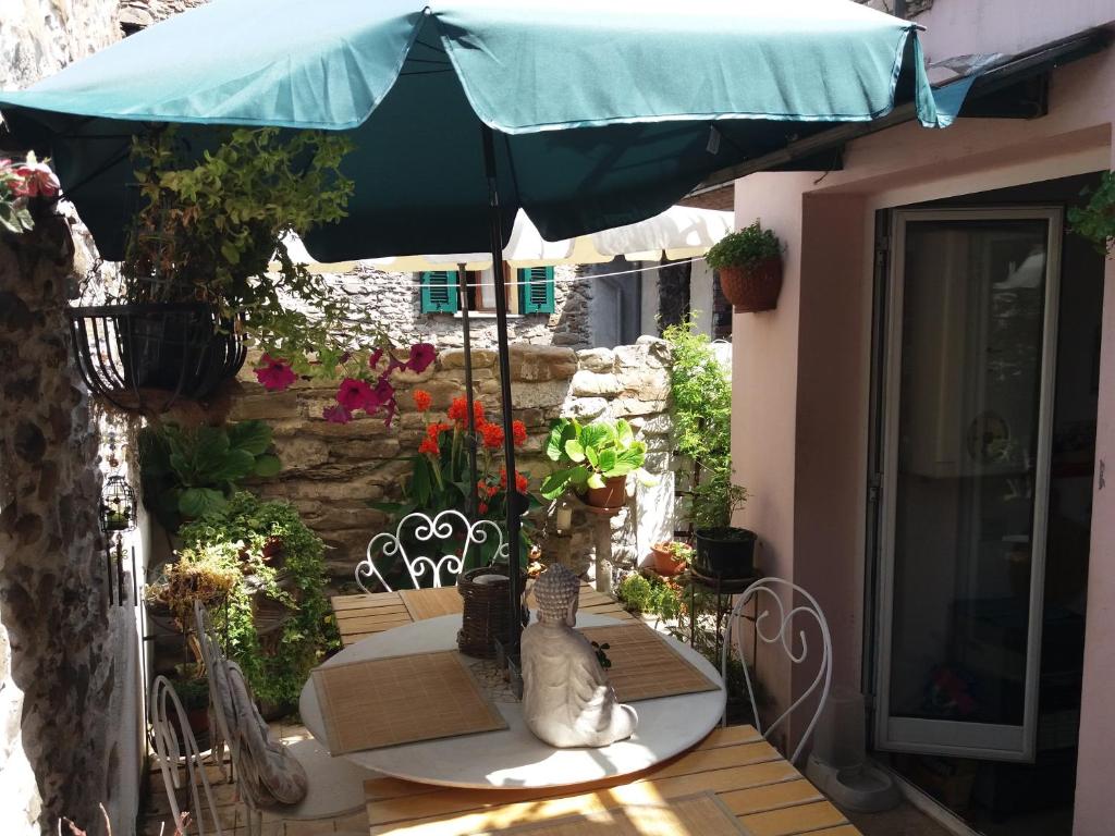 - une table avec un parasol bleu sur la terrasse dans l'établissement Casa Med Holiday Home, à Isolabona