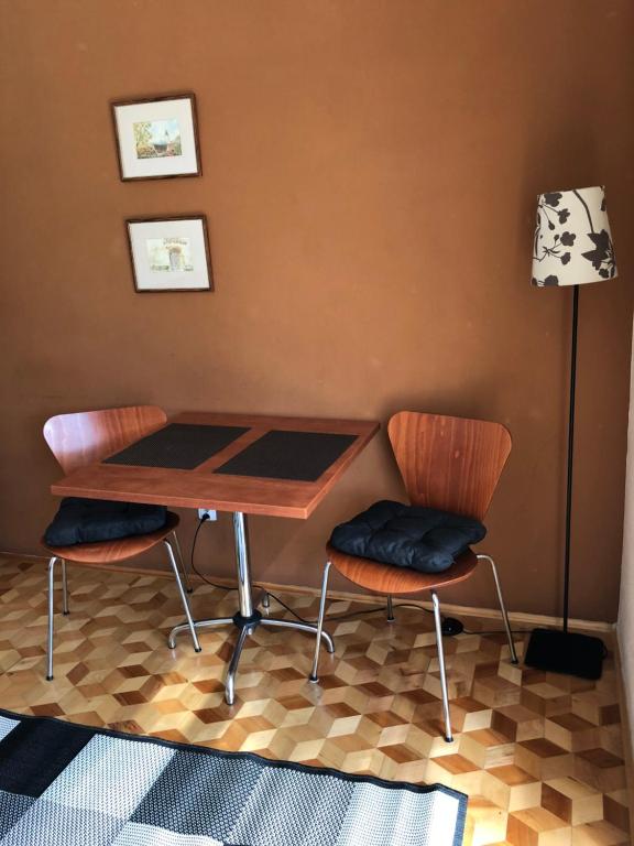 シュツァブニツァにあるApartament EPI Szczawnicaのテーブルと椅子2脚、ランプが備わります。