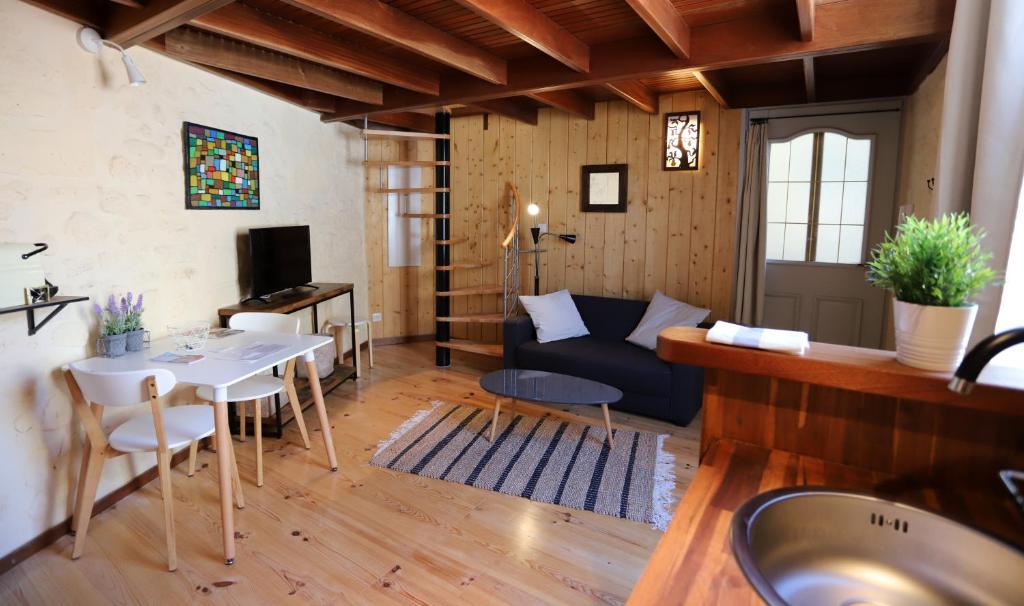 a living room with a couch and a table at Les Appartements de la Victoire, Centre-ville, Possibilité Parking GRATUIT in Bordeaux