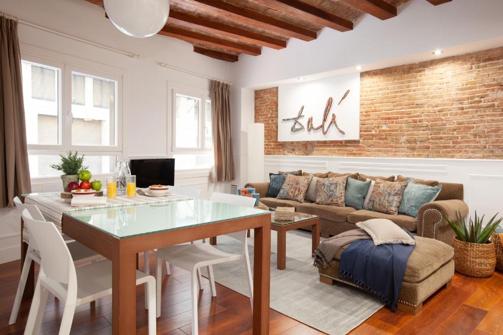 sala de estar con mesa y sofá en Enjoybcn Dali Apartments en Barcelona