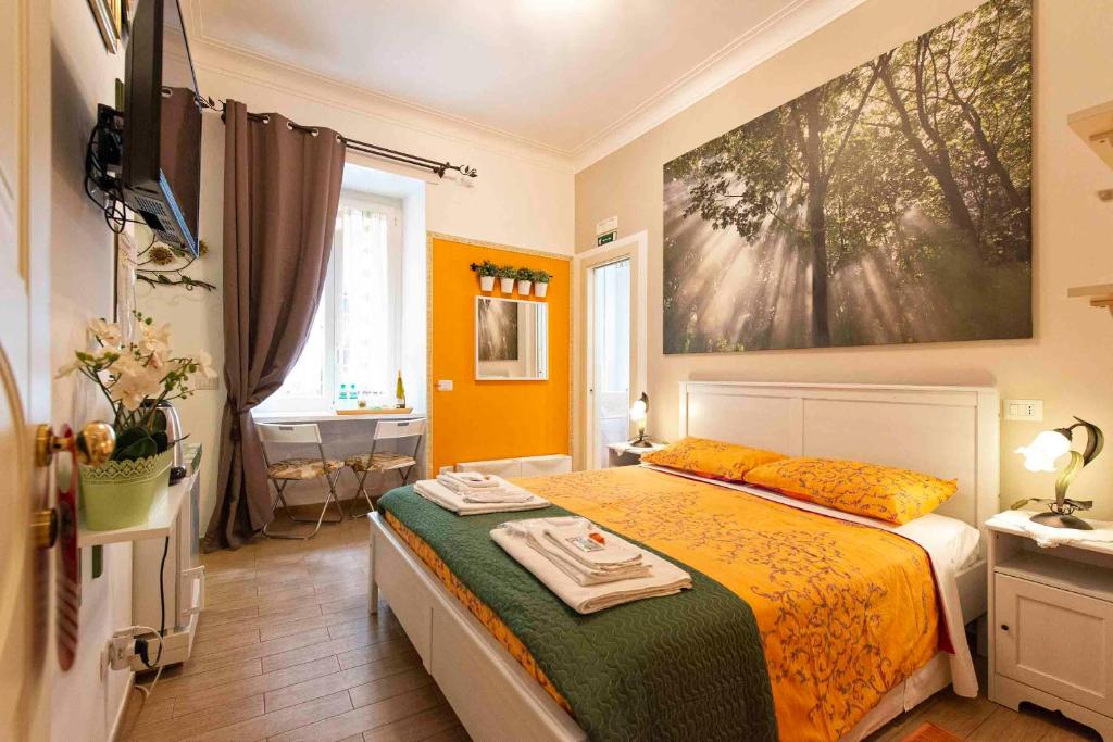 ローマにあるEtere in Prati Roomsのベッドルーム1室(ベッド1台付)が備わります。壁には絵画が飾られています。