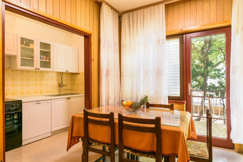 a kitchen with a table with chairs and a window at Trogir apartment Blaga in Trogir