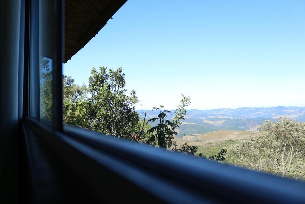a view of the mountains from a window at Chale Vista Encantada in Lavras Novas