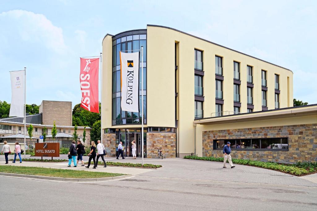 un edificio con gente caminando delante de él en Hotel Susato en Soest