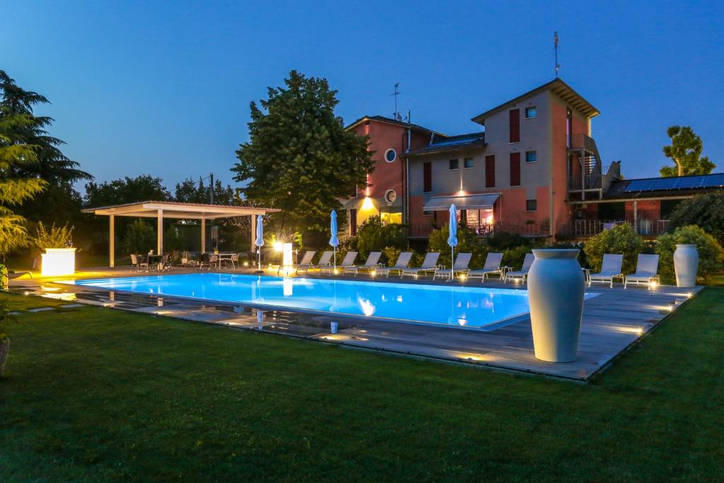 a swimming pool in a yard with chairs and a building at Residenza Cartiera 243 Country House in Villorba