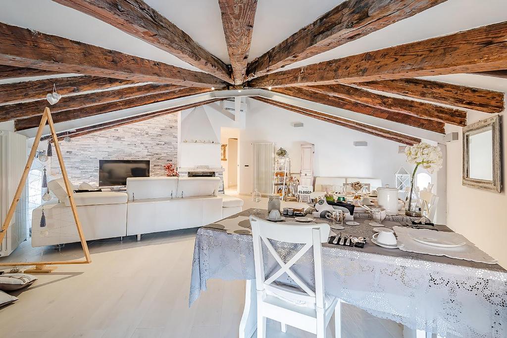 a living room with wooden ceilings and a table and chairs at Addicted to Paradise b&b in Trieste