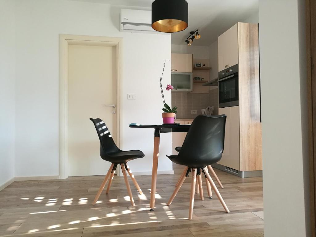 a kitchen with a table and two black chairs at Apartment Gabi in Umag