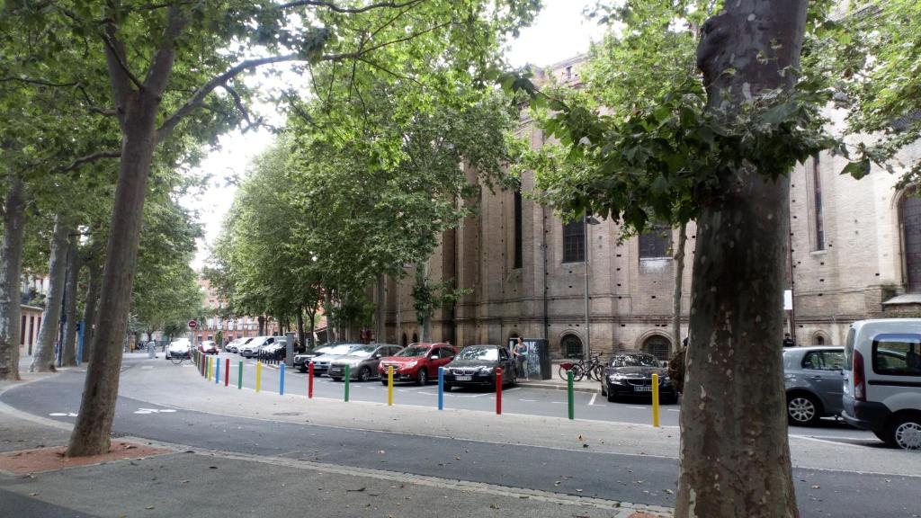 a street with cars parked on the side of a building at Résidence le Pastel François Verdier in Toulouse