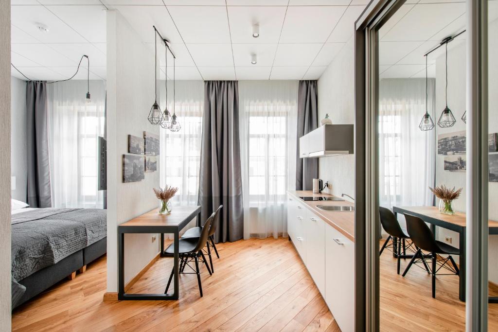 考納斯的住宿－Piano Apartments，卧室配有一张床和一张桌子及椅子