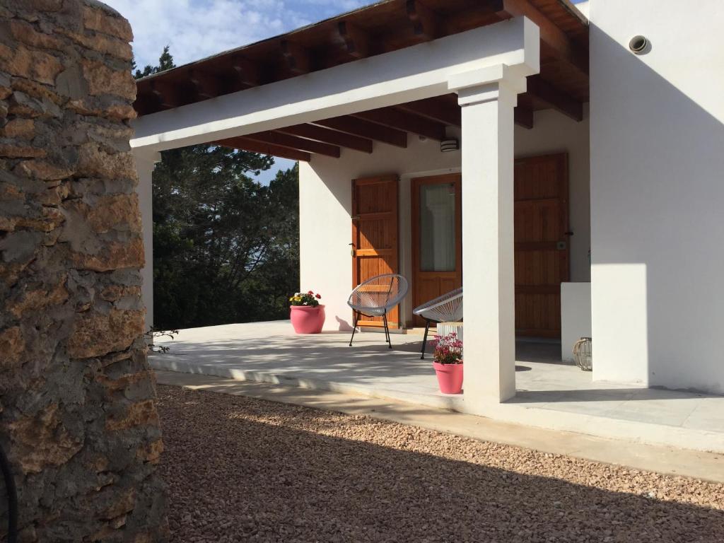 a patio with awning and a chair on a house at Es Lliri Blanc in Cala Saona
