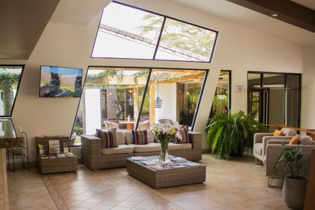 uma sala de estar com sofás e flores numa mesa em Hotel Ladera em Boquete