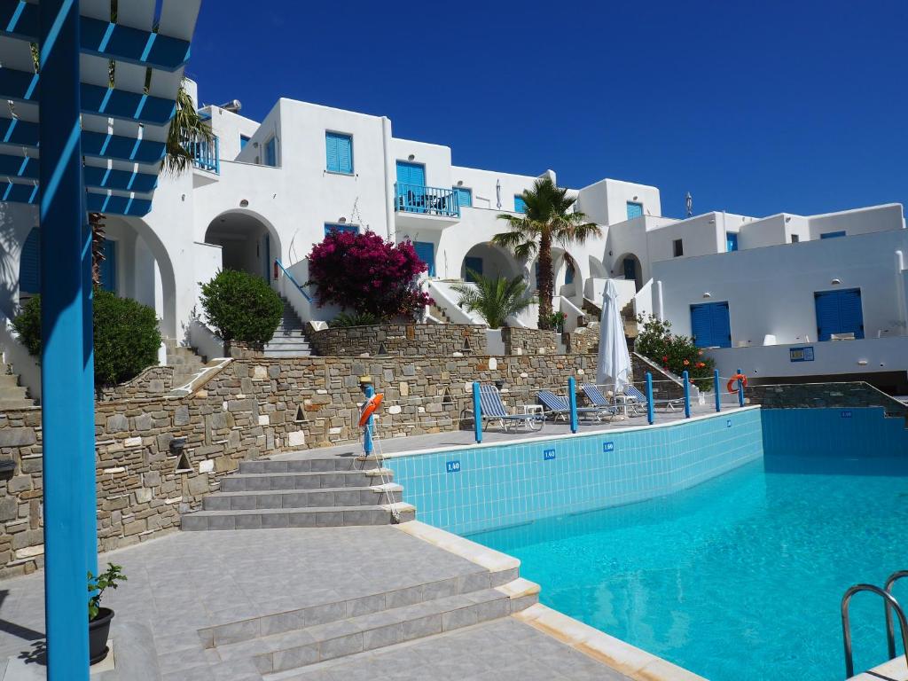 a swimming pool in front of a building at Arkas Inn in Logaras